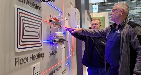 Zwei SHK-Fachleute auf der ISH-Messe vor einem Demonstrationsmodell für eine moderne Heizungs-/Warmwasseranlage